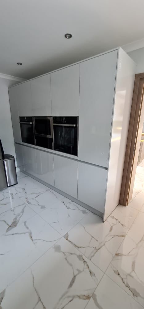 White shiny ceramic kitchen, black oven and cupboards installation